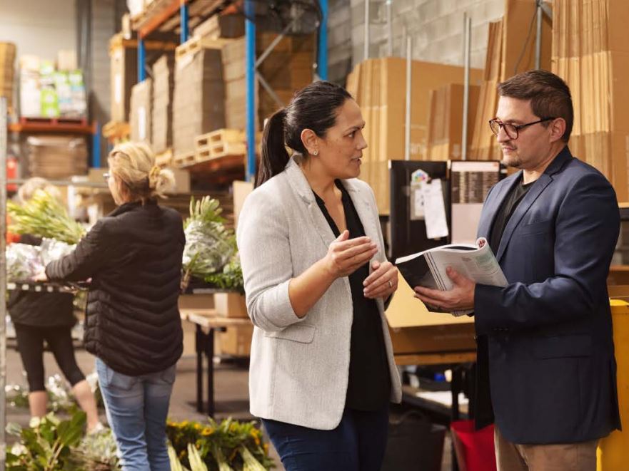 2 people having conversation in warehouse