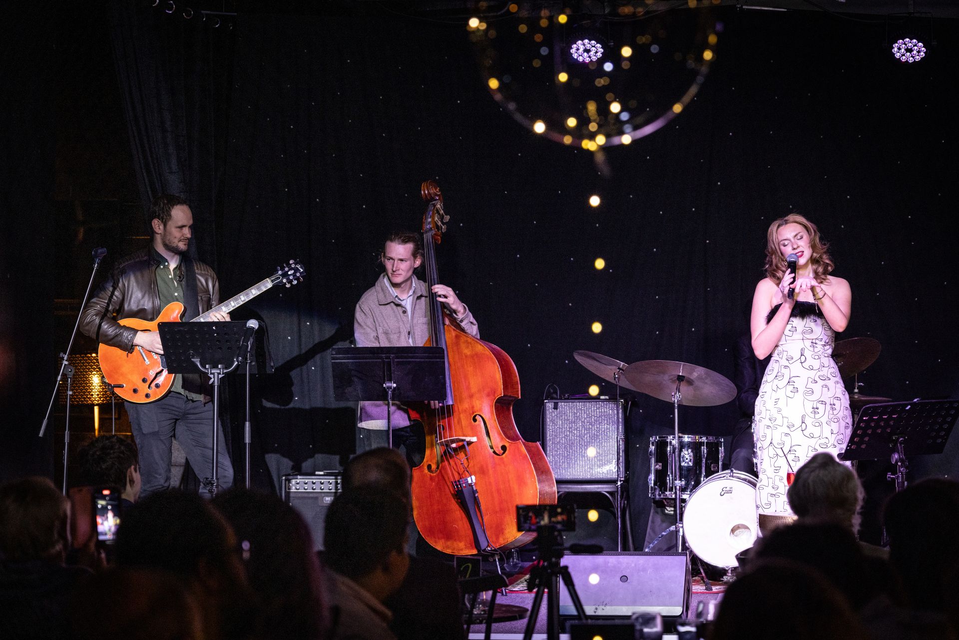 Woman performing on stage with a band
