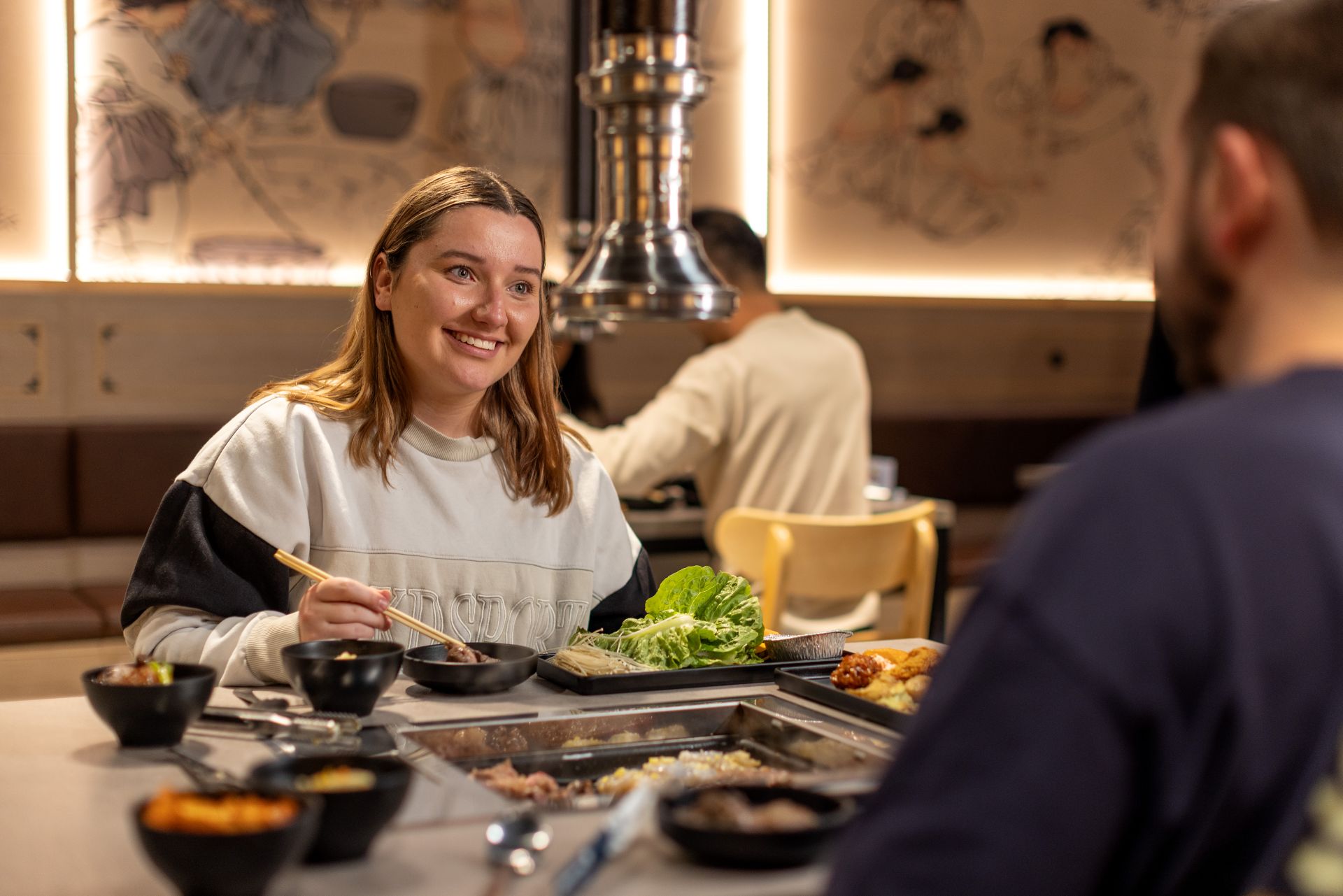 A couple having Korean barbecue at a restaurant