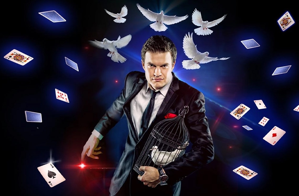 Magician with a dove in a cage surrounded by cards