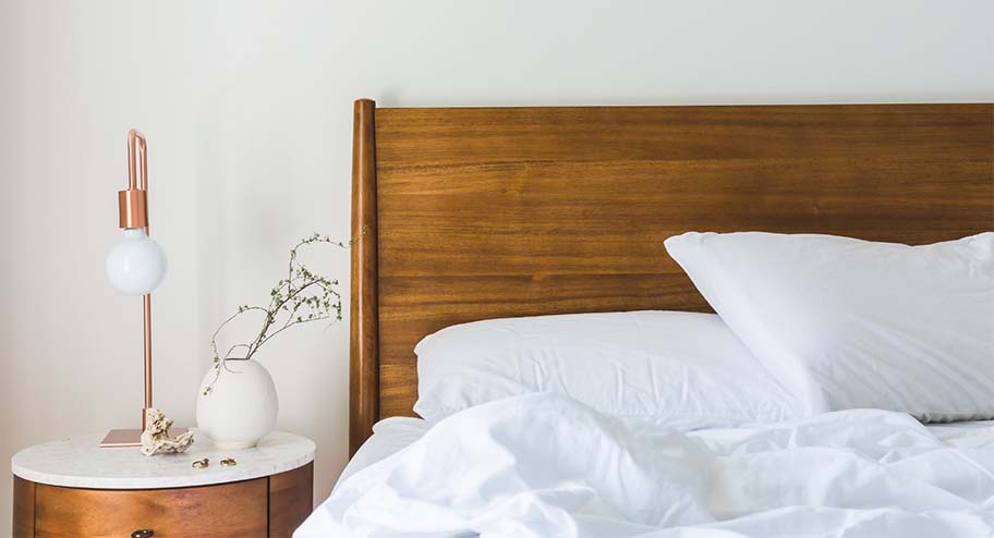 bed with white sheets and a wooden headboard