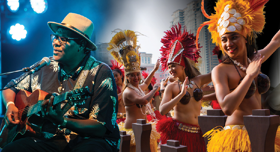 Man plays guitar while dancers in cultural dress dance behind him