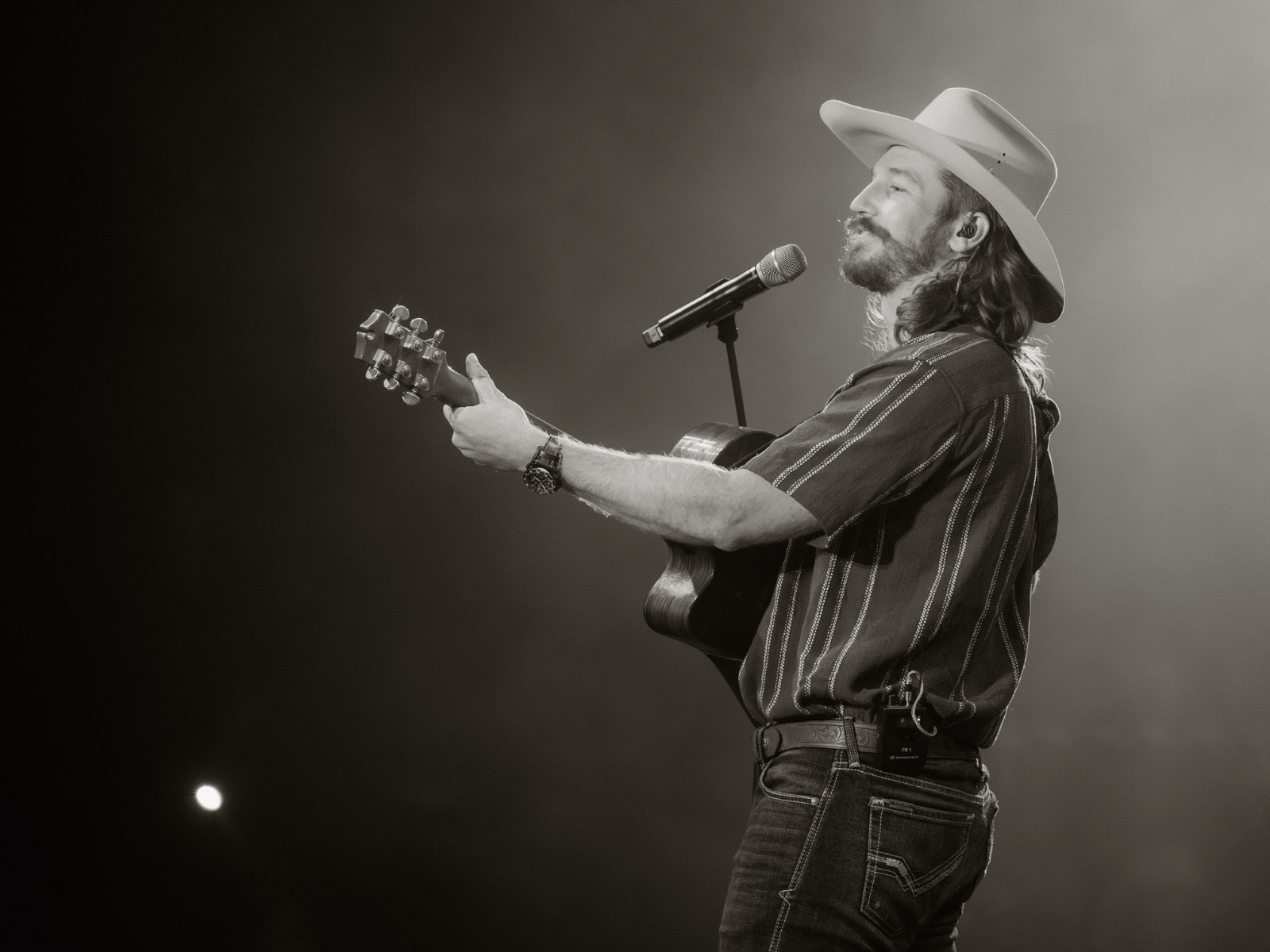 Jake Whittaker on stage performing with guitar in black and white photo.